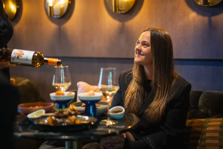 Gast aan tafel in Bar Blue met verfijnde gerechten en wijn